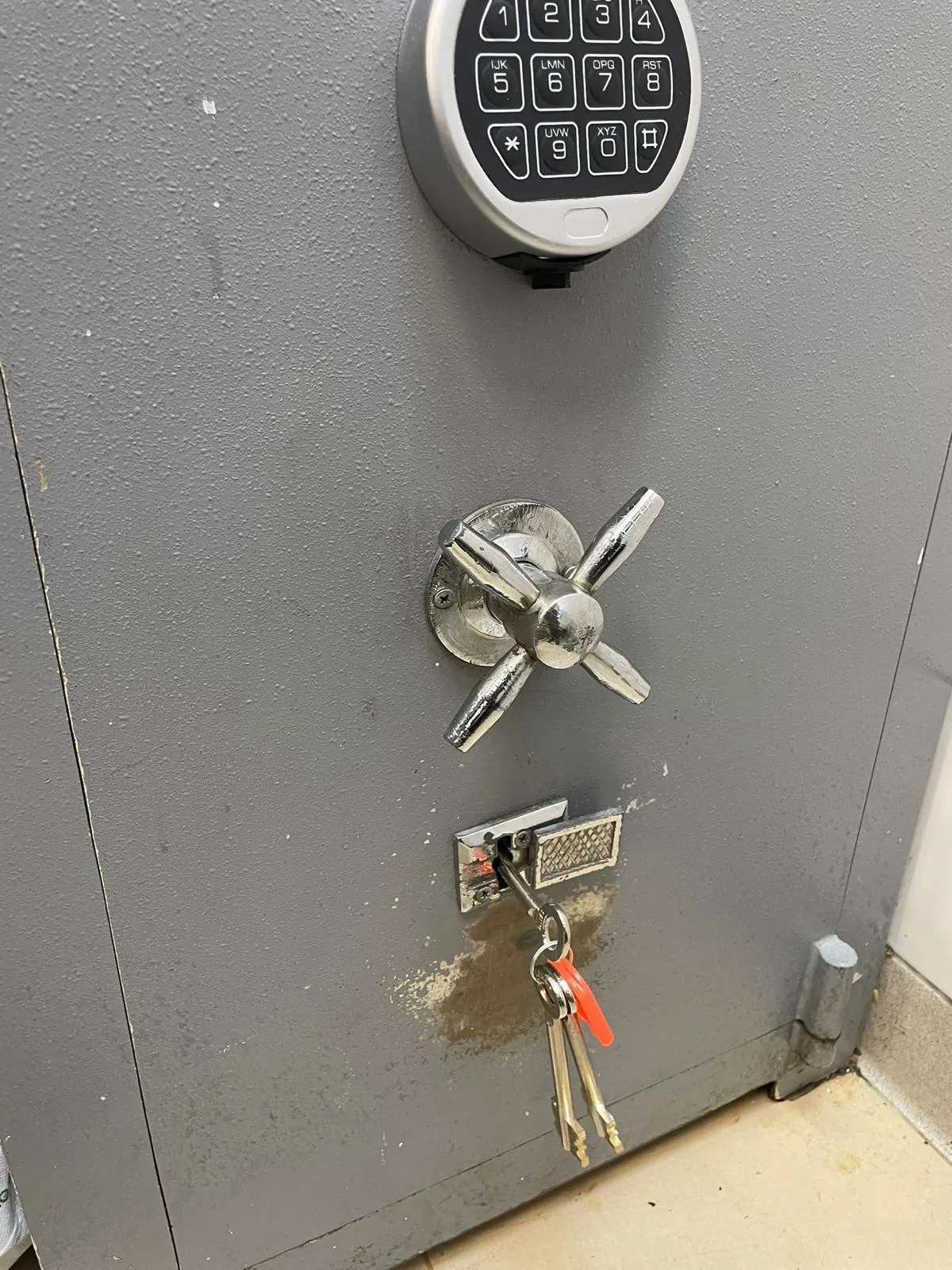 Gri Antep kasasının kapağında elektronik şifre tuş takımı, krom çevirmeli kol ve anahtarın takılı olduğu kilit